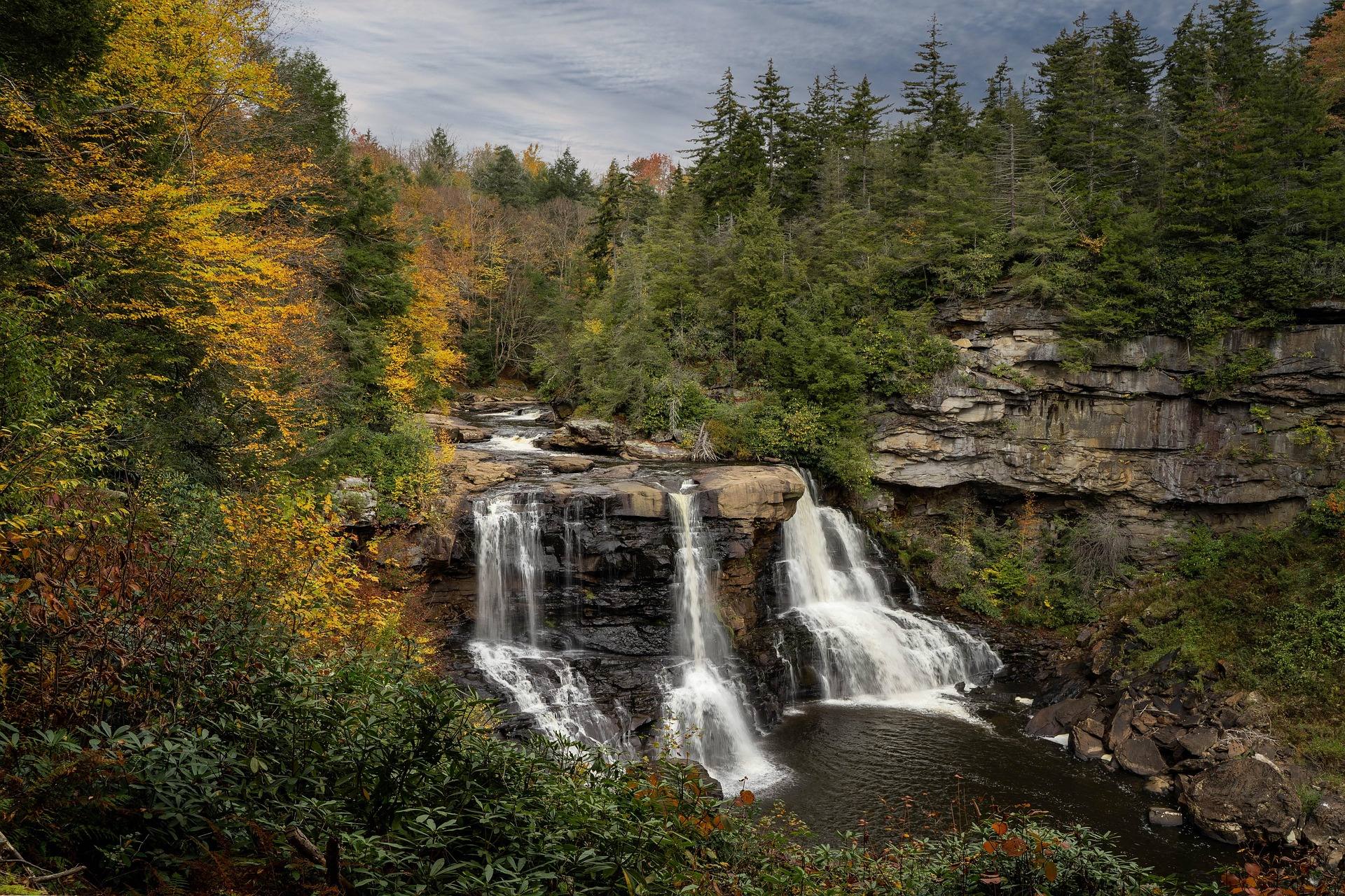 Blackwater Falls tumbling over layered rock ledges surrounded by autumn color at Blackwater Falls State Park, West Virginia