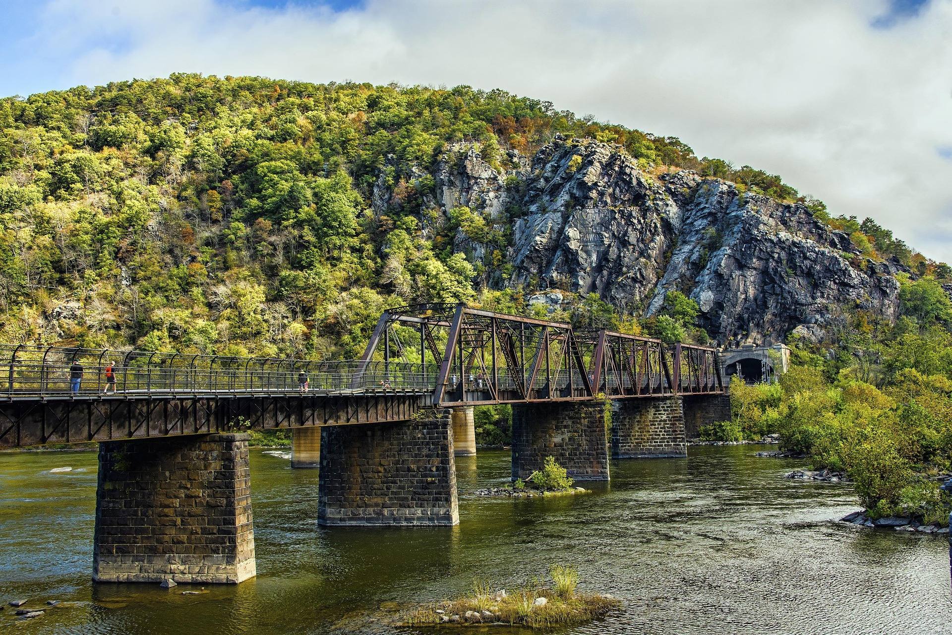 Historic railroad and footbridge crossing the Potomac River at Harpers Ferry, West Virginia, with Maryland Heights cliffs behind