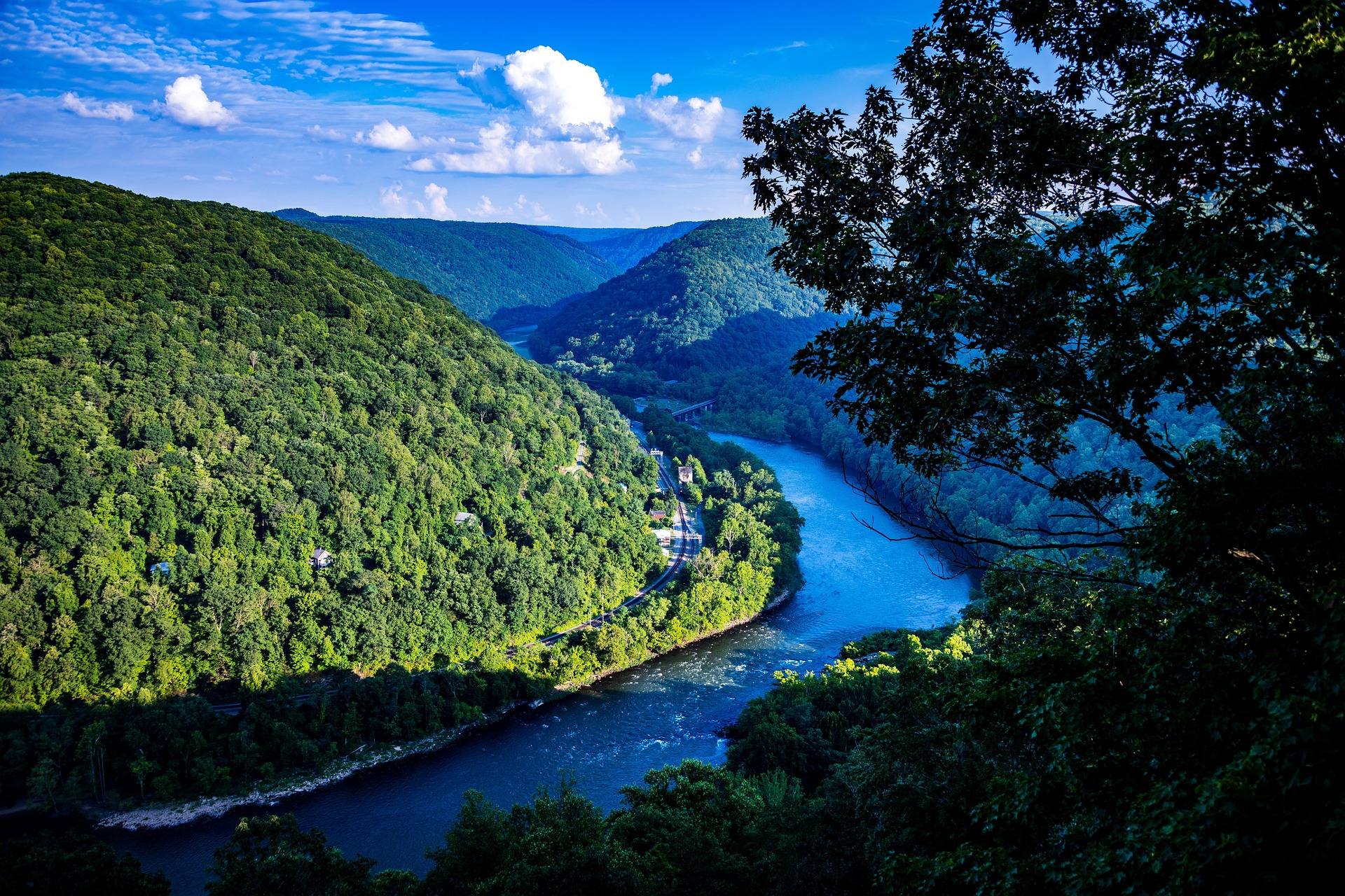 Summer view from a New River Gorge overlook looking down the winding New River through forested mountains in West Virginia
